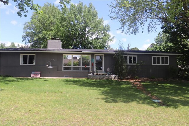 back of house with a chimney, a lawn, and crawl space