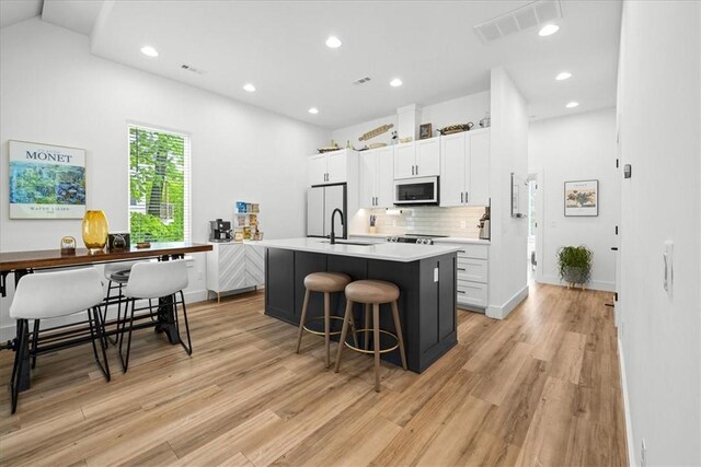 7 Thornbury Ln, Bella Vista, AR 72714 - kitchen with a sink, light wood-type flooring, a kitchen island with sink, white cabinets, and recessed lighting