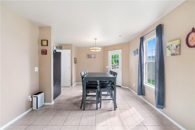 dining space featuring baseboards and light tile patterned floors