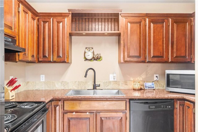 kitchen with appliances with stainless steel finishes, under cabinet range hood, a sink, brown cabinets, and light stone counters