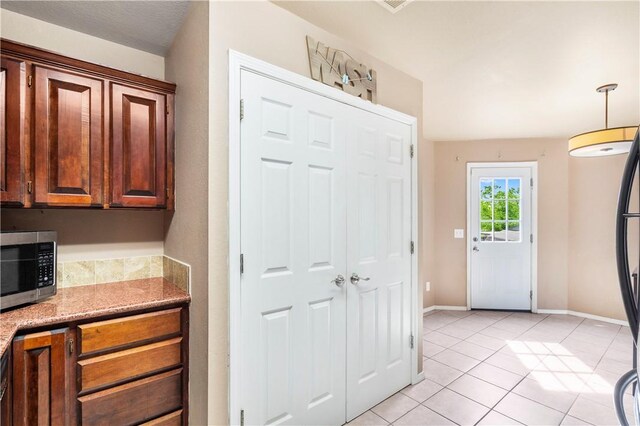 foyer entrance featuring light tile patterned floors and baseboards