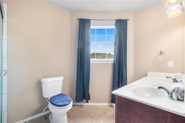 bathroom with toilet, baseboards, tile patterned flooring, and double vanity
