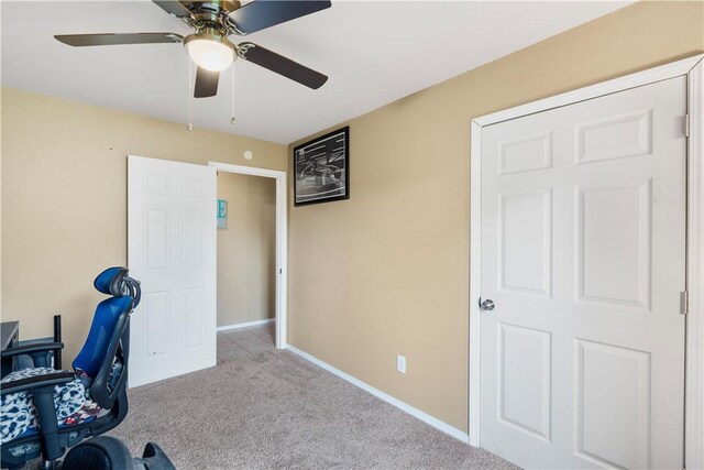 unfurnished office featuring carpet, baseboards, and ceiling fan
