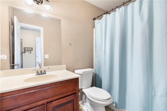 full bathroom featuring toilet, vanity, and curtained shower