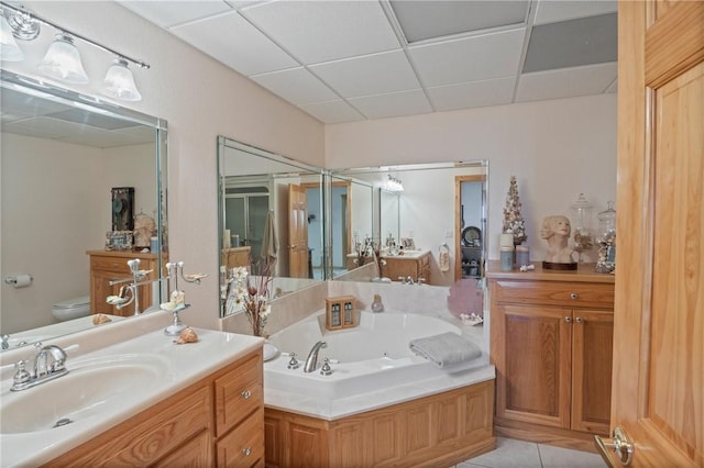 full bathroom featuring a paneled ceiling, toilet, a bath, tile patterned floors, and vanity