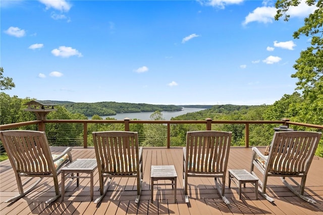 wooden terrace featuring a water view and a forest view