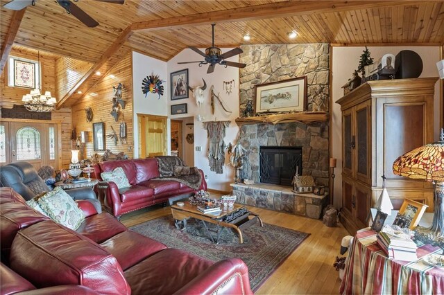 living area with ceiling fan, wooden ceiling, a chandelier, high vaulted ceiling, and a stone fireplace