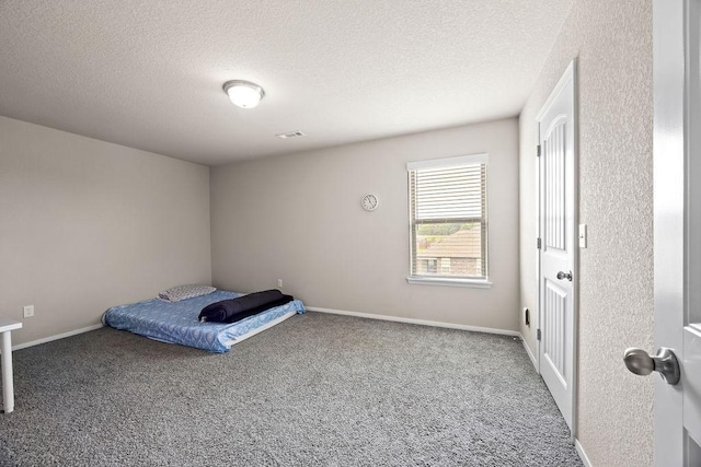 unfurnished bedroom featuring a textured ceiling, carpet flooring, and baseboards