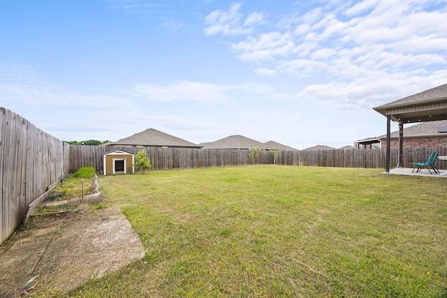 view of yard with a storage shed, an outbuilding, and a patio