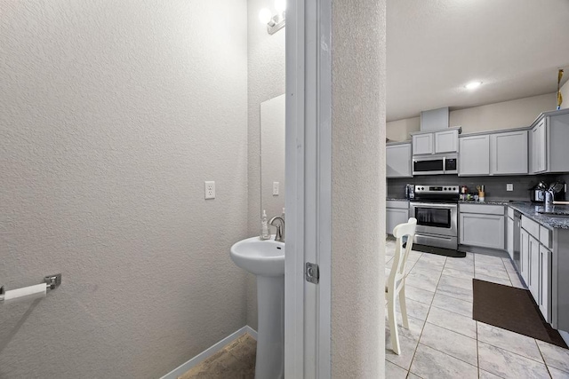 bathroom with a textured wall and a sink