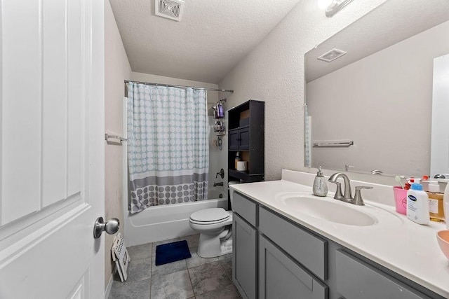 full bathroom featuring vanity, shower / bath combination with curtain, toilet, and a textured ceiling