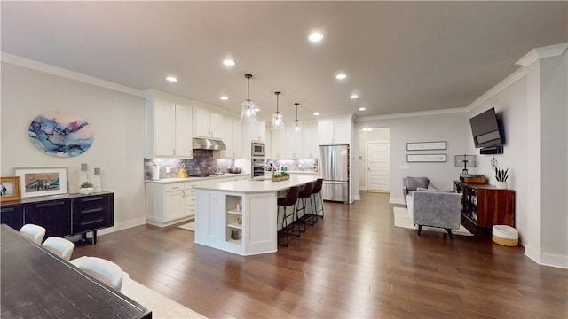 kitchen with appliances with stainless steel finishes, a breakfast bar area, white cabinets, ornamental molding, and light countertops