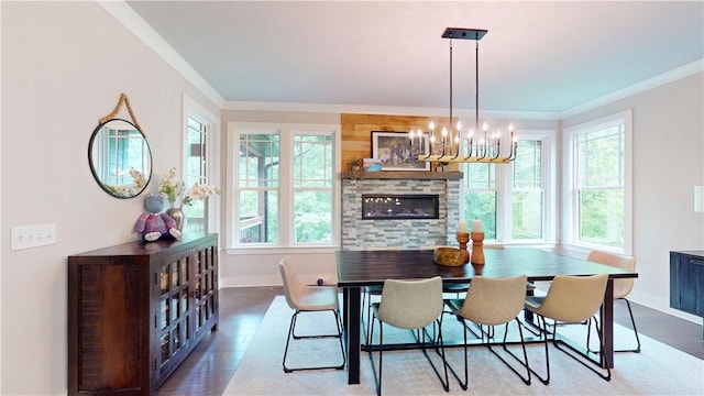 dining space featuring baseboards, wood finished floors, crown molding, and a chandelier