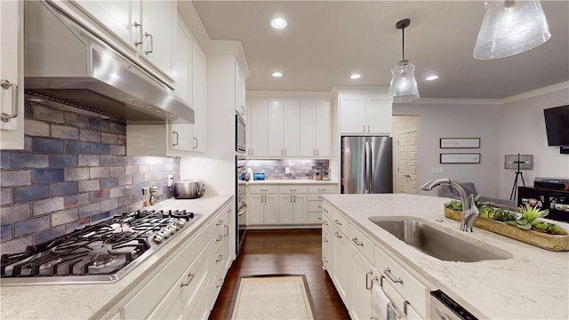 kitchen featuring appliances with stainless steel finishes, under cabinet range hood, a sink, dark wood-style flooring, and recessed lighting