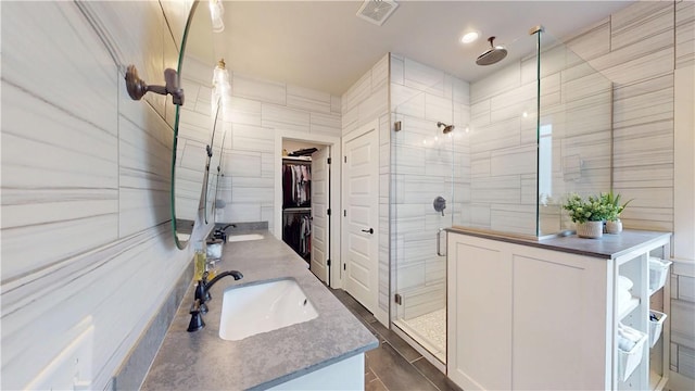 full bathroom featuring a shower stall, double vanity, and a spacious closet