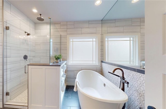 bathroom featuring tile walls, a shower stall, a soaking tub, tile patterned floors, and recessed lighting