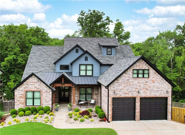 view of front facade with concrete driveway, brick siding, a porch, a standing seam roof, and roof with shingles