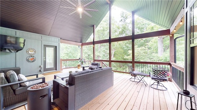 sunroom / solarium featuring a ceiling fan, lofted ceiling, and an outdoor living space