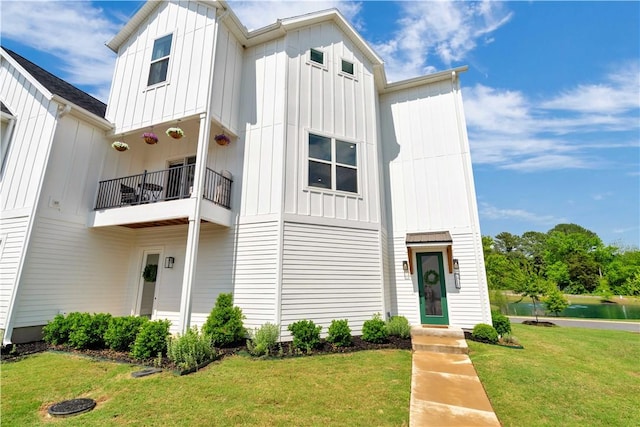 2630 N Gulley Grove Cir, Fayetteville, AR 72703 - view of front facade featuring board and batten siding, a balcony, a front yard, and a water view