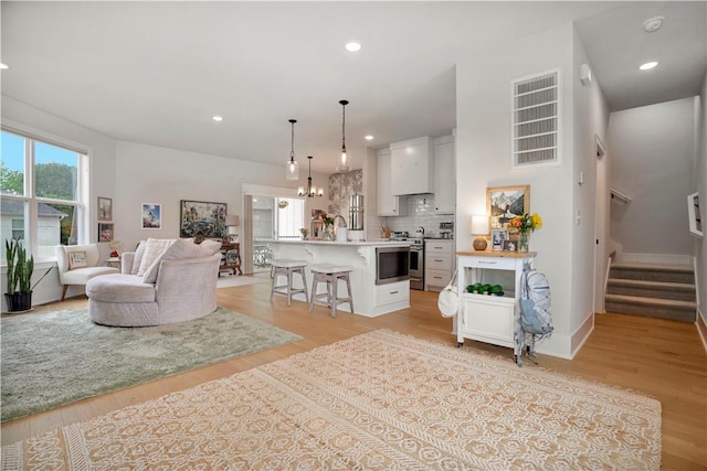2630 N Gulley Grove Cir, Fayetteville, AR 72703 - living area featuring stairs, light wood-style floors, recessed lighting, and baseboards