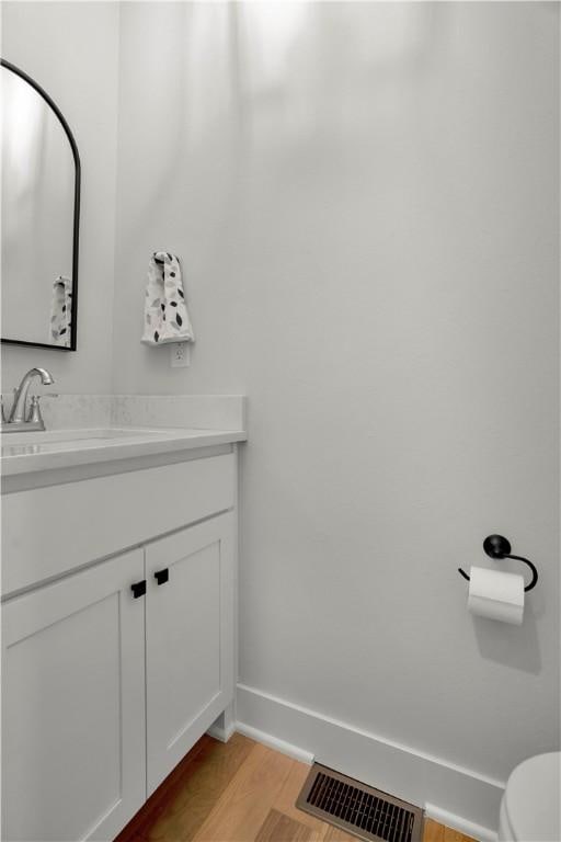 2630 N Gulley Grove Cir, Fayetteville, AR 72703 - bathroom with wood finished floors, vanity, baseboards, and toilet