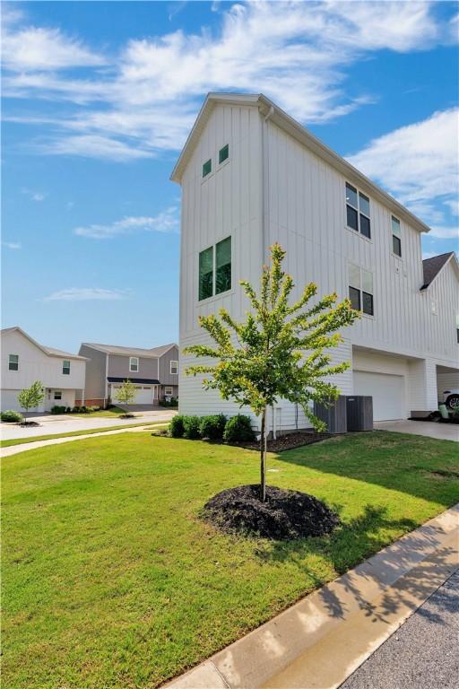 2630 N Gulley Grove Cir, Fayetteville, AR 72703 - view of front of property with board and batten siding, an attached garage, driveway, and a front yard