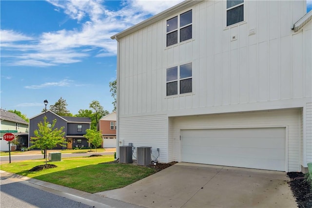 2630 N Gulley Grove Cir, Fayetteville, AR 72703 - view of home's exterior featuring an attached garage, a lawn, central air condition unit, board and batten siding, and driveway