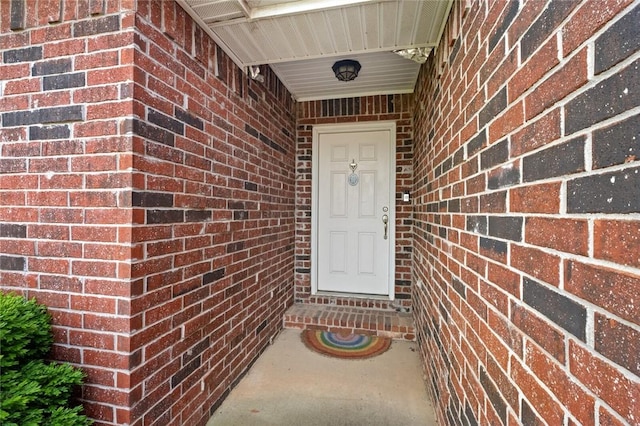 entrance to property featuring brick siding