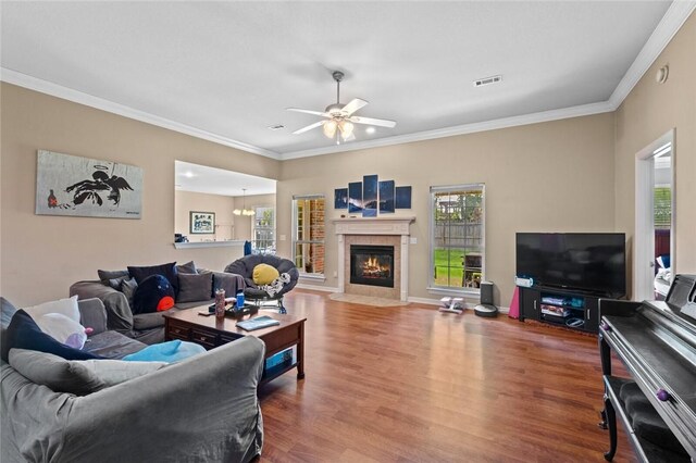 living area with wood finished floors, plenty of natural light, and crown molding