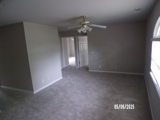 carpeted empty room with ceiling fan and baseboards