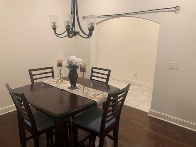 214 Hunt St, Pea Ridge, AR 72751 - dining area featuring a chandelier, baseboards, wood finished floors, and arched walkways