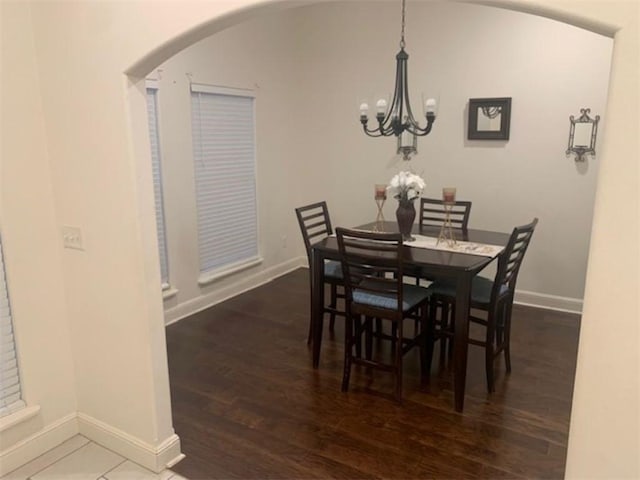 214 Hunt St, Pea Ridge, AR 72751 - dining space featuring arched walkways, baseboards, a chandelier, and wood finished floors
