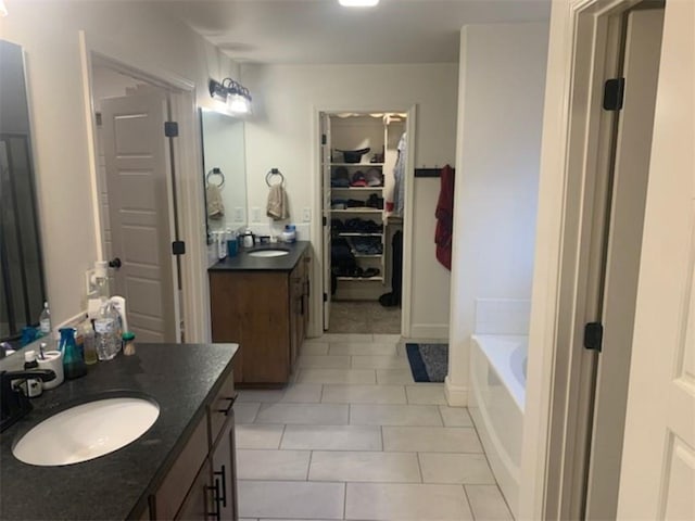 214 Hunt St, Pea Ridge, AR 72751 - bathroom with two vanities, tile patterned flooring, a garden tub, and a walk in closet