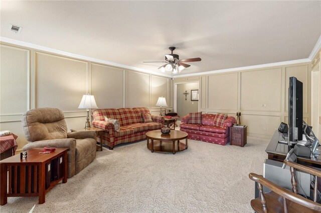 living area featuring a decorative wall, a ceiling fan, and carpet