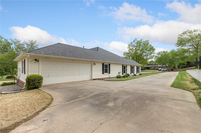 ranch-style house with driveway, a garage, and roof with shingles