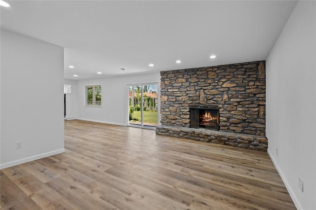 1104 S 12th St, Rogers, AR 72756 - unfurnished living room with recessed lighting, wood finished floors, a stone fireplace, and baseboards