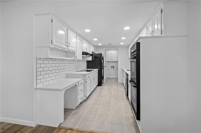1104 S 12th St, Rogers, AR 72756 - kitchen with under cabinet range hood, white cabinets, light countertops, backsplash, and recessed lighting