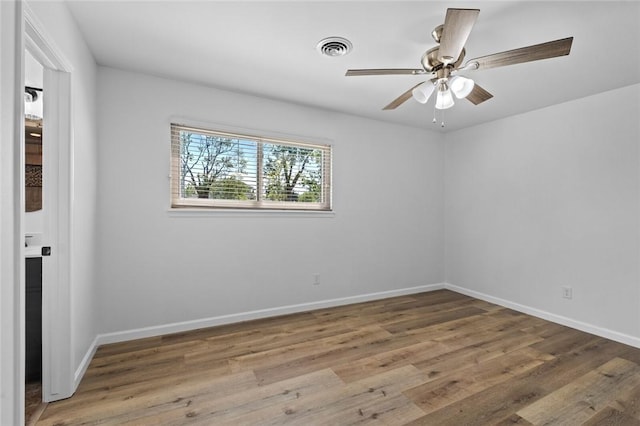 1104 S 12th St, Rogers, AR 72756 - unfurnished room featuring wood finished floors, baseboards, and a ceiling fan