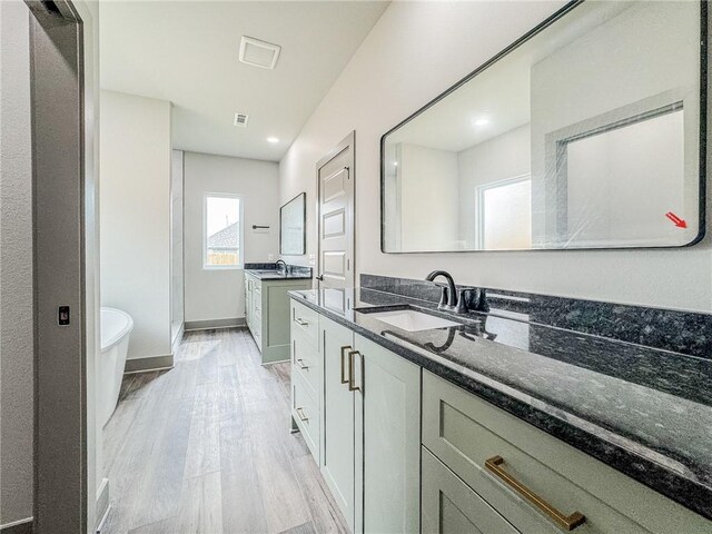181 Magazine, Prairie Grove, AR 72753 - full bathroom with wood finished floors, two vanities, a freestanding bath, baseboards, and a shower stall