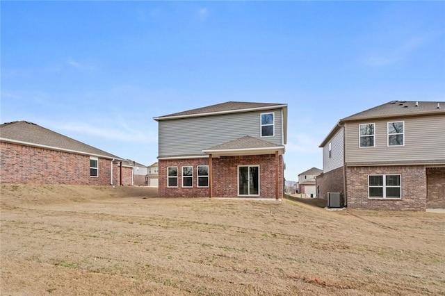 rear view of property with central air condition unit and brick siding