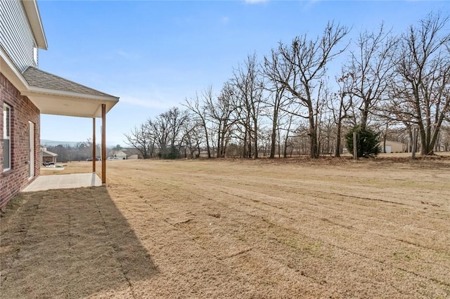 view of green lawn with a patio area