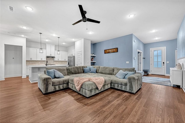 living area featuring ceiling fan, wood finished floors, recessed lighting, and baseboards