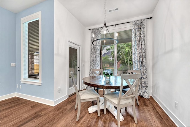 dining area featuring a chandelier, plenty of natural light, dark wood-style floors, and baseboards