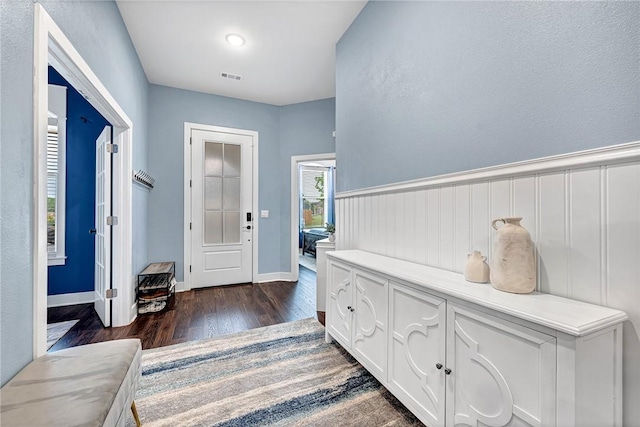 entrance foyer with dark wood-style floors and baseboards