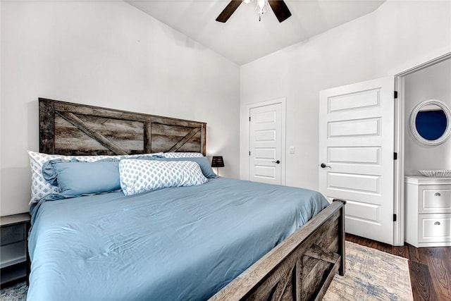 bedroom with dark wood-style floors, vaulted ceiling, and a ceiling fan