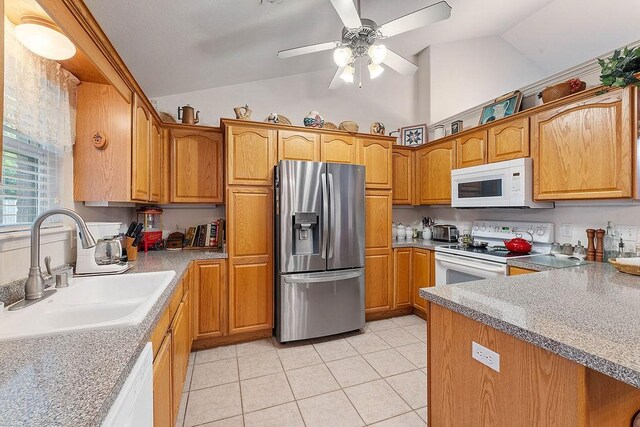 kitchen with white appliances, a sink, light tile patterned floors, a ceiling fan, and brown cabinets