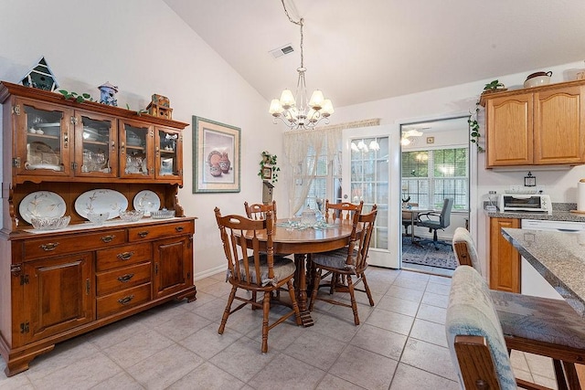 dining room with a chandelier, vaulted ceiling, light tile patterned floors, and baseboards