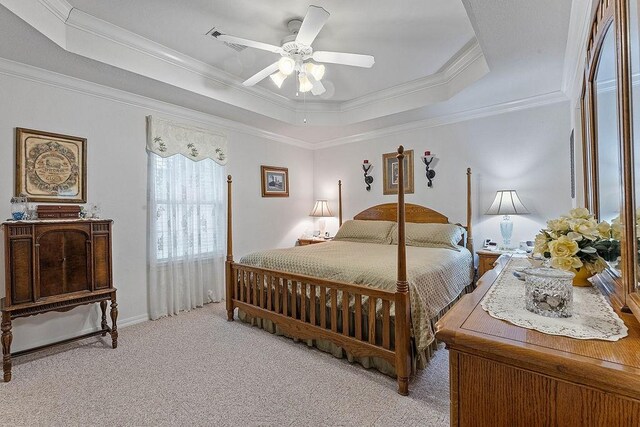 bedroom with a tray ceiling, light carpet, ornamental molding, and a ceiling fan