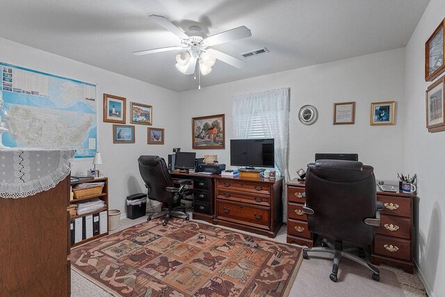 office space with a ceiling fan and light colored carpet