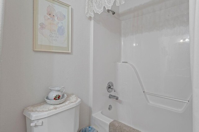 bathroom featuring toilet and shower / bathtub combination
